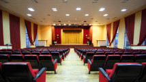 Concert hall and empty stage, many rows of red seats and stage