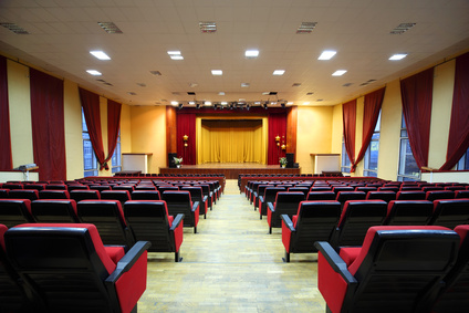 Concert hall and empty stage, many rows of red seats and stage